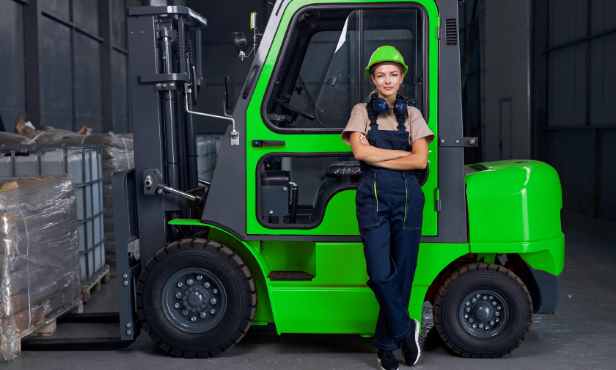 Girl standing in front of green forklift