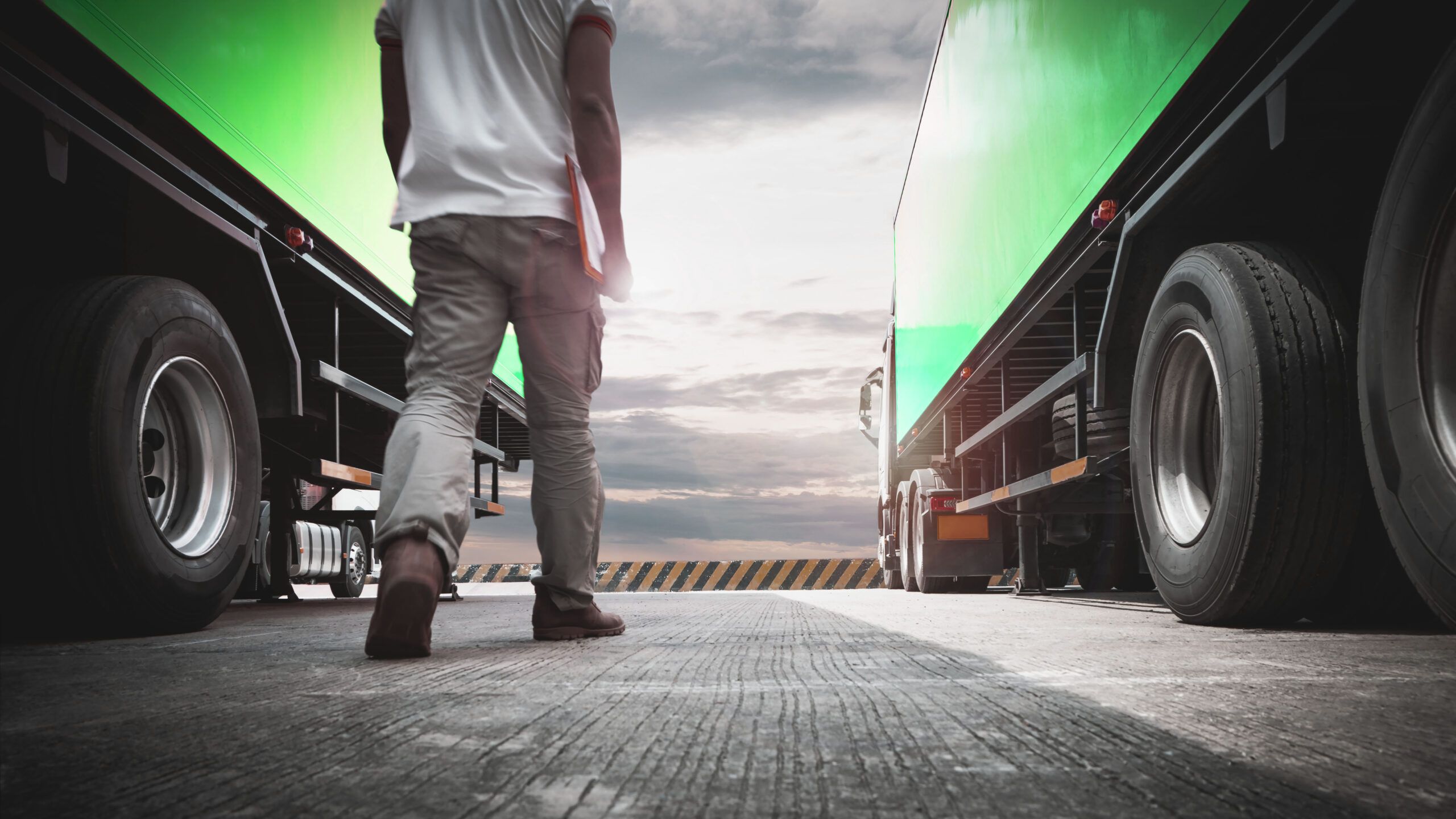 visually convey the concept of civil liability insurance importance in the photo of a person standing between two Express Heroes trucks